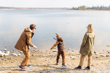 Wall Mural - father teaching little son throw rocks in water