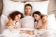© Pixel-Shot - Man with two beautiful women in bed. Polyamory concept