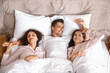© Pixel-Shot - Man with two beautiful women in bed. Polyamory concept