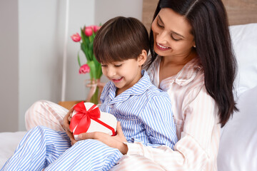 Poster - Little son and his mother with gift for International Women's day in bedroom at home