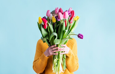 pretty charming young woman dressed yellow clothes holding tulip bunch isolated blue color background