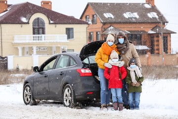 Poster - Family in medical masks near car on snowy winter day