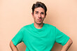 © Asier - Young caucasian man isolated on beige background confused, feels doubtful and unsure.