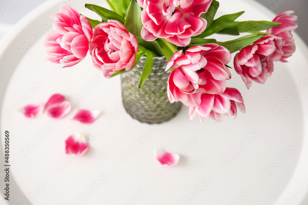 Vase with tulips on table, closeup