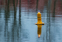 A Warning Yellow Buoy Floating On The Water 