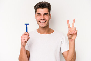 Young caucasian man shaving his beard isolated on white background showing number two with fingers.