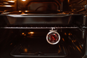 Thermometer for food is measuring temperature in oven.