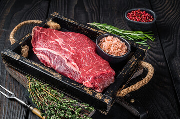 Unccoked rump steak or raw top sirloin beef meat steak. Black wooden background. Top view