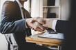 © Pormezz - hand of client and banker shaking hands  on the meeting table after business investment budget done
