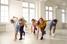 Group Of Young People Dancing. Happy, Cheerful, Beautiful, Talented Male And Female Contemporary Dancers In Casual Wear Enjoying Music And Moving Synchronously During Rehearsal In Modern Dance Hall