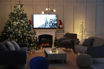 Cozy living room interior with beautiful Christmas tree near fireplace