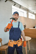© Kostiantyn - Male worker in work overalls holding hammer
