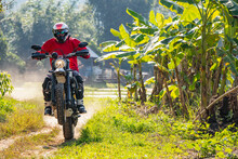 Man Riding His Scrambler Type Motorcycle On Rugged Terrain In Thailand