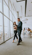 © BGStock72 - Young entrepreneur couple walking together and using digital tablet in the modern office