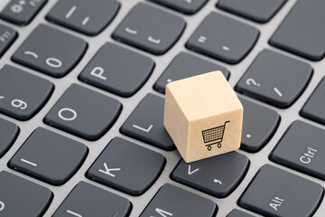 Fototapete - Wooden block with shopping cart graphic on computer keyboard