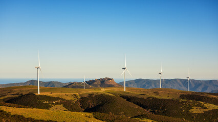 Wall Mural - wind turbines on a beautiful sunset sky in a mountain wind farm in sardinia. renewable energy concep