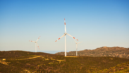 Wall Mural - wind turbines on a beautiful sunset sky in a mountain wind farm in sardinia. renewable energy concep