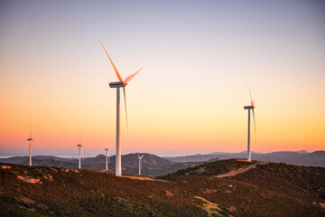 Wall Mural - wind turbines on a beautiful sunset sky in a mountain wind farm in sardinia. renewable energy concep