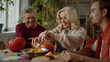© iaginzburg - Grandmother tries to carefully cut off the top of the pumpkin and communicates with her grandson and husband