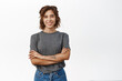 Happy smiling young hispanic woman, wearing grey t-shirt, looking cheerful, standing confident against white background
