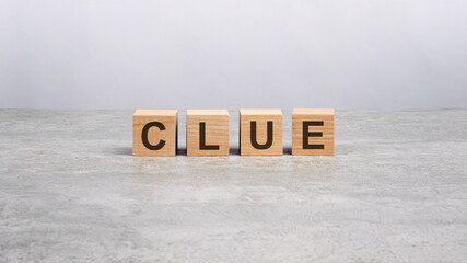 Poster - four wooden blocks with the word CLUE on the gray table. business concept