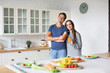 © BestForYou - Portrait young couple in the kitchen looking at the camera. Healthy eating, time together