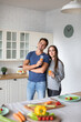 © BestForYou - Portrait young couple in the kitchen looking at the camera. Healthy eating, time together