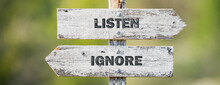 Opposite Signs On Wooden Signpost With The Text Quote Listen Ignore Engraved. Web Banner Format.
