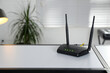 Modern Wi-Fi router on table indoors. Space for text