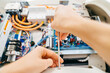© andrey - hand of engineer with screwdriver assembles medical equipment after repair