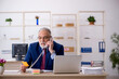 © Elnur - Old male employee working in the office