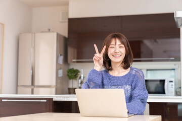 Canvas Print - 部屋でラップトップコンピューターを見る女性