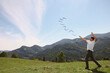 Man throwing boomerang in mountains on sunny day. Space for text