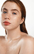 Portrait of redhead plus size female model with freckles and blue eyes, concept of skin care, body and shower, looking at camera. Curvy young woman posing for cosmetic product, white background