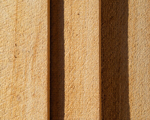 Natural background made of wooden planks. The wooden surface is made of light pine boards lying on top of each other with a shadow. Abstract textured yellow background