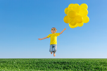 Canvas Print - Happy child jumping in green spring field