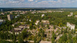 Aerial view abandoned buildings and streets overgrown with trees in central square city Pripyat near Chernobyl nuclear power plant. Drone shot Exclusion Zone in summer. Radiation