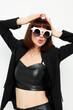 © Tatiana - photo pretty woman in a black jacket red nail polish stylish sunglasses light background