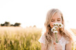 © Westend61 - Blond girl smelling flowers in field