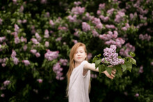 Girl Holding Lilac Flowers In Nature