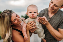 Happy Parents With Cute Baby Son Making Funny Face