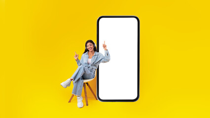 Happy lady listening to music near big empty mobile screen