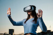 © Westend61 - Young woman using virtual reality simulator gesturing in front of sunset sky
