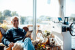 © Westend61 - Cheerful senior man with tablet PC sitting at houseboat