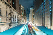 Light Trails On Railroad Tracks Amidst Buildings In City At Night
