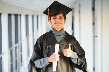 Wall Mural - portrait of successful indian student in graduation gown.