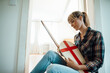 © Westend61 - Woman sitting with wooden sword and shield at home