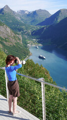 Poster - Tourist taking photo of fjord landscape, Norway