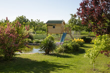 Children Wooden Playhouse In The Beautiful Garden Near The Lake