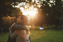 Affectionate Couple Hugging At Backyard Sunset